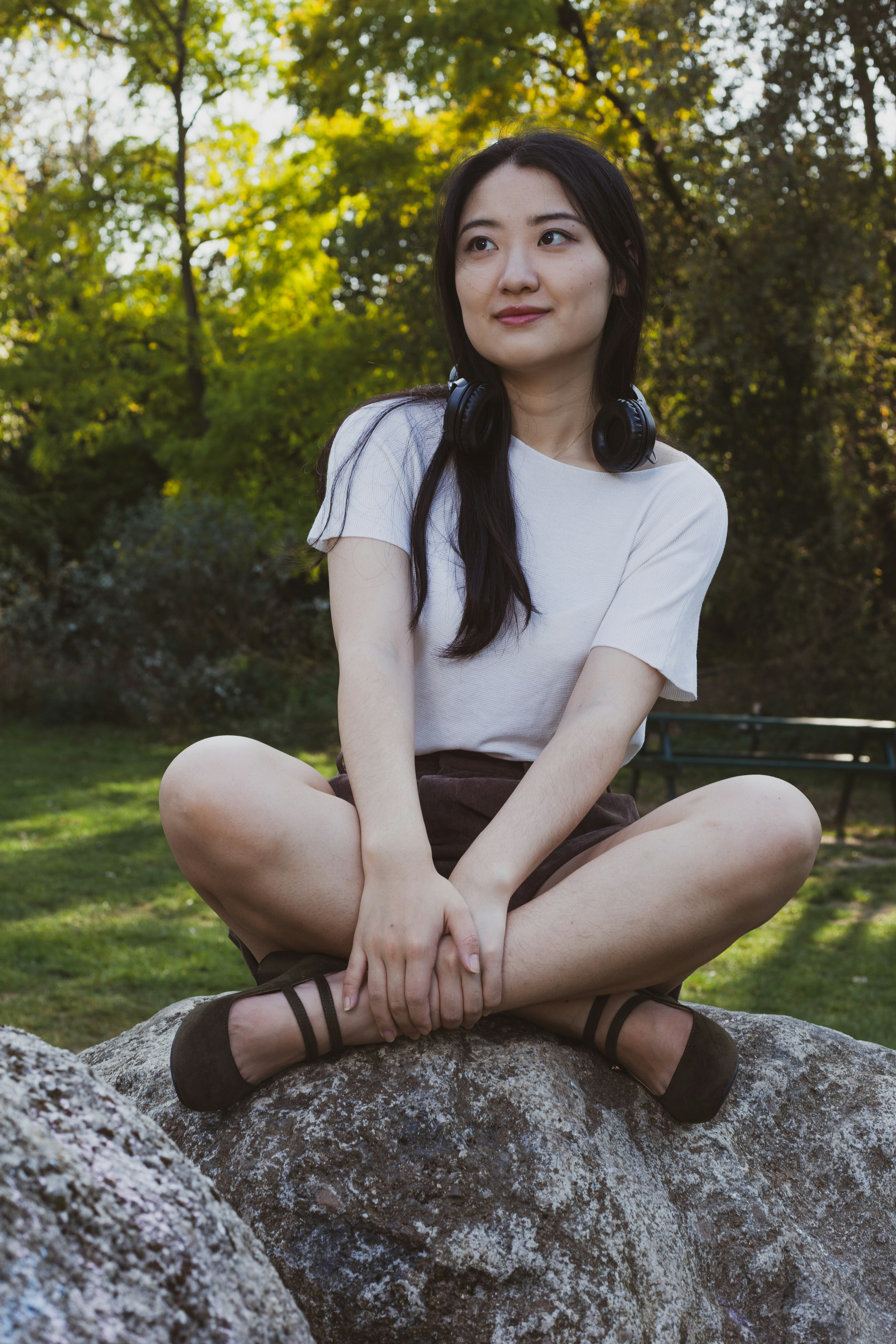 Femme en T-shirt blanc assise sur un rocher