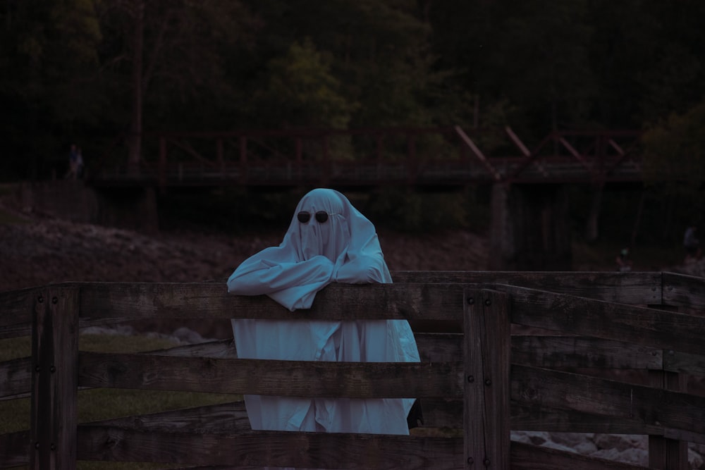 Personne en sweat à capuche blanc assise sur un banc en bois brun