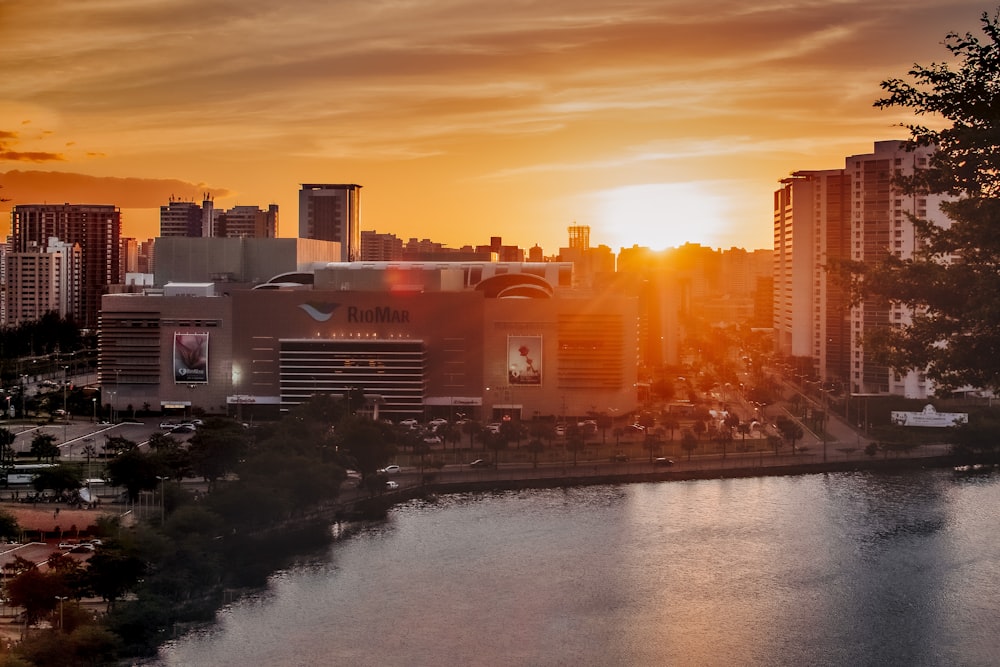 body of water near city buildings during sunset