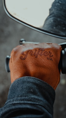 person in brown leather jacket and black denim jeans riding on motorcycle