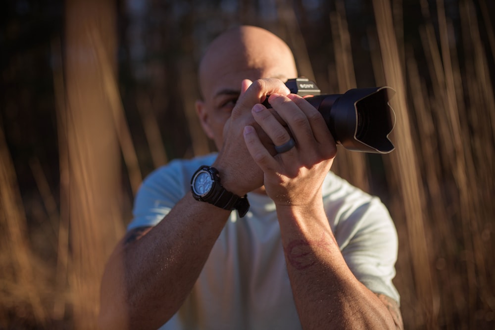 man in white t-shirt drinking from black ceramic mug