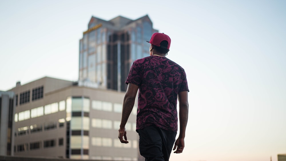 man in red and black crew neck t-shirt and black pants wearing red cap