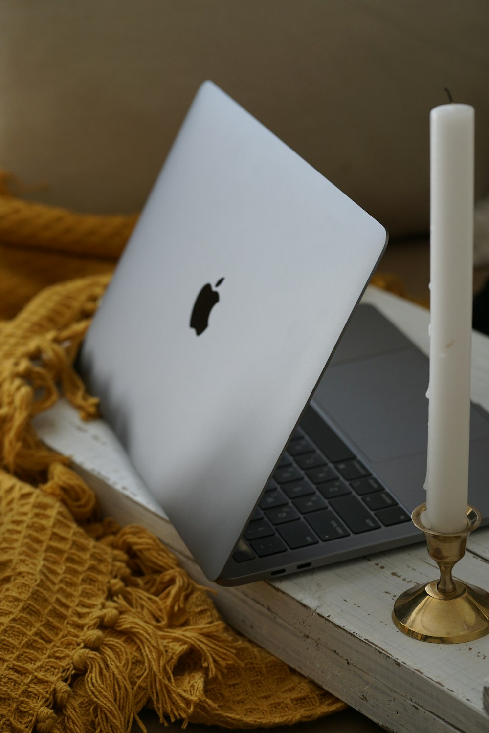 silver macbook on brown textile