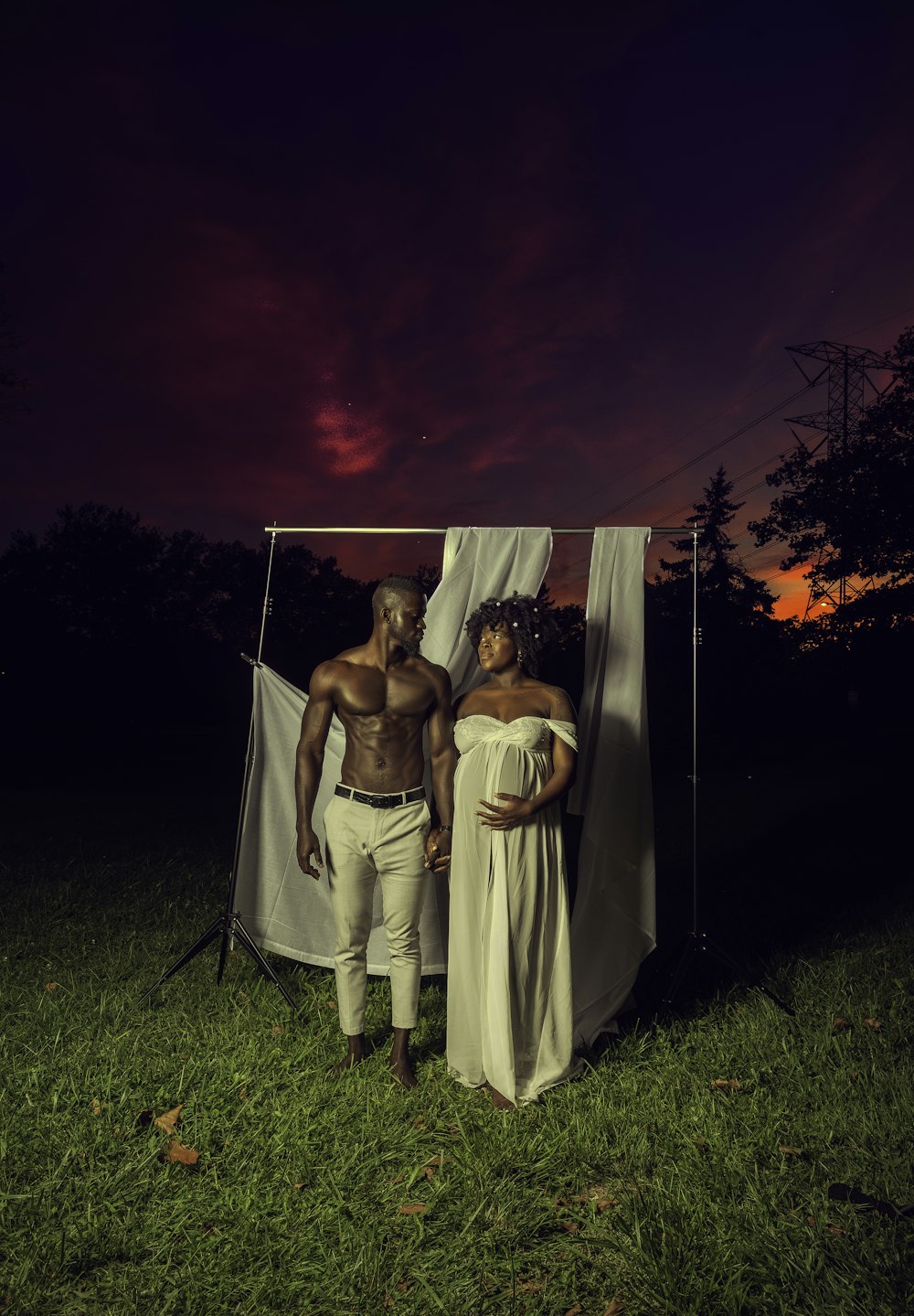 woman in white dress standing beside man in white dress shirt