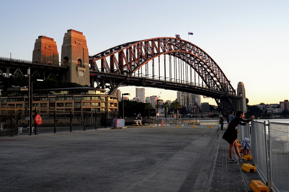 people walking on gray concrete road near brown concrete bridge during daytime