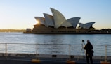 Sunrise over Sydney Opera House with the harbor shimmering in golden light.