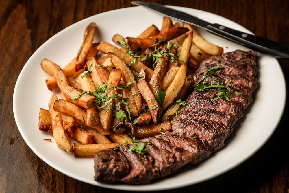 carne a la brasa sobre plato de cerámica blanca