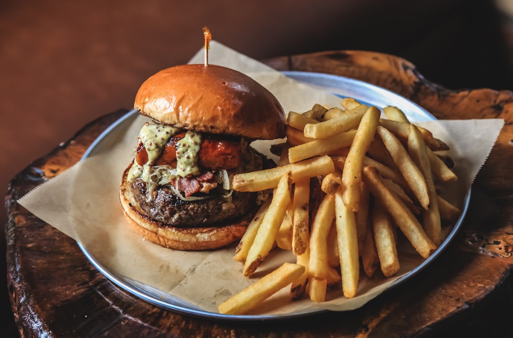 Hamburguesa con patatas fritas en plato de cerámica blanca