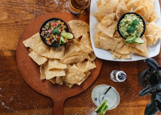 Overhead shot of chips salsa, guac, a margarita, and someone who is very irresponsible with the salt. Part of the C9 Work WordPress Theme sample content imagery.