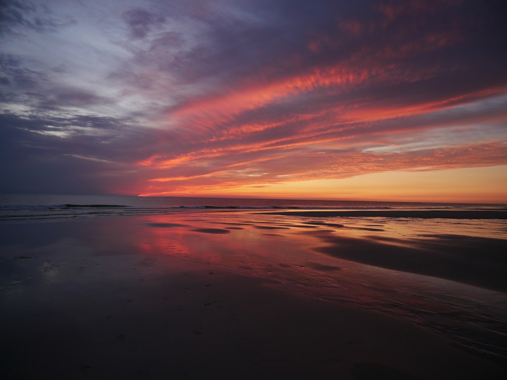 body of water under cloudy sky during sunset