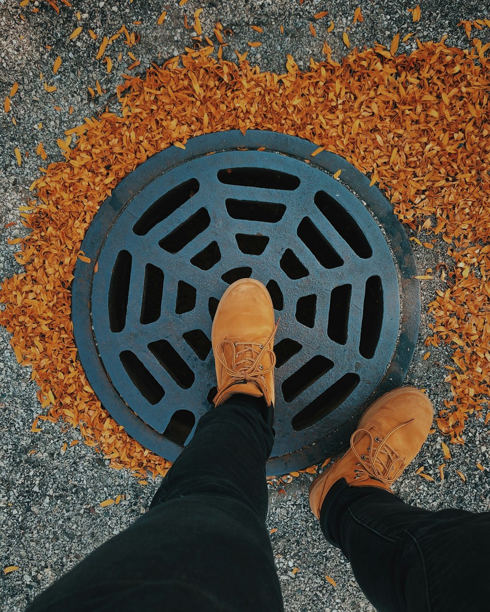 person in black pants and brown leather shoes standing on brown metal round frame