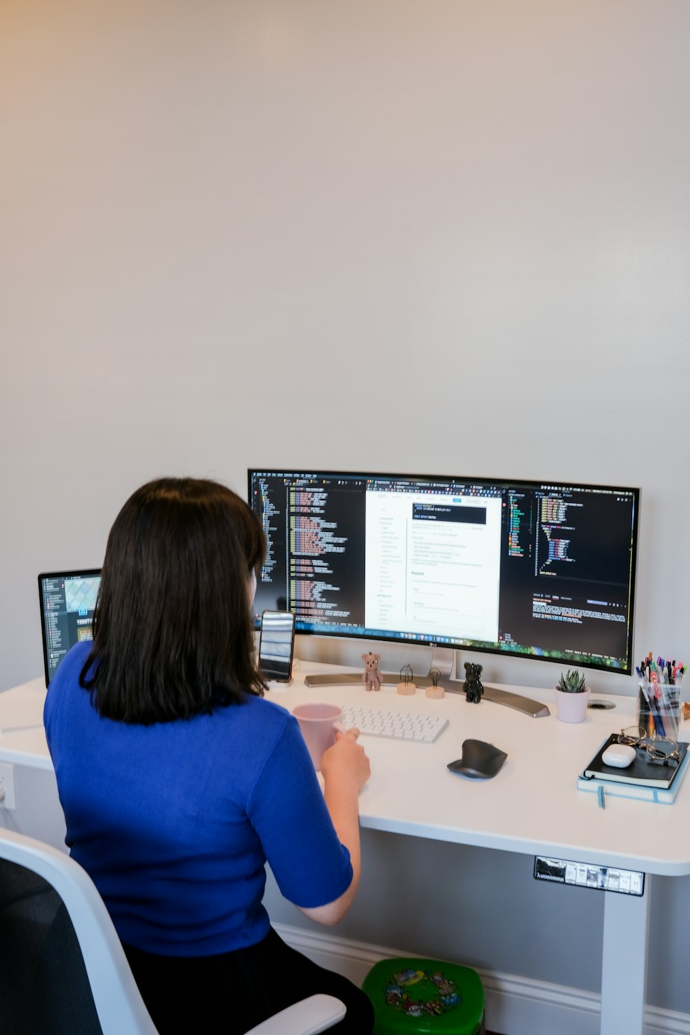 Mujer con camisa azul sentada frente a la computadora