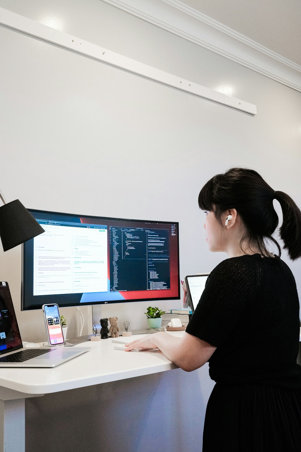 a woman standing in front of a computer monitor