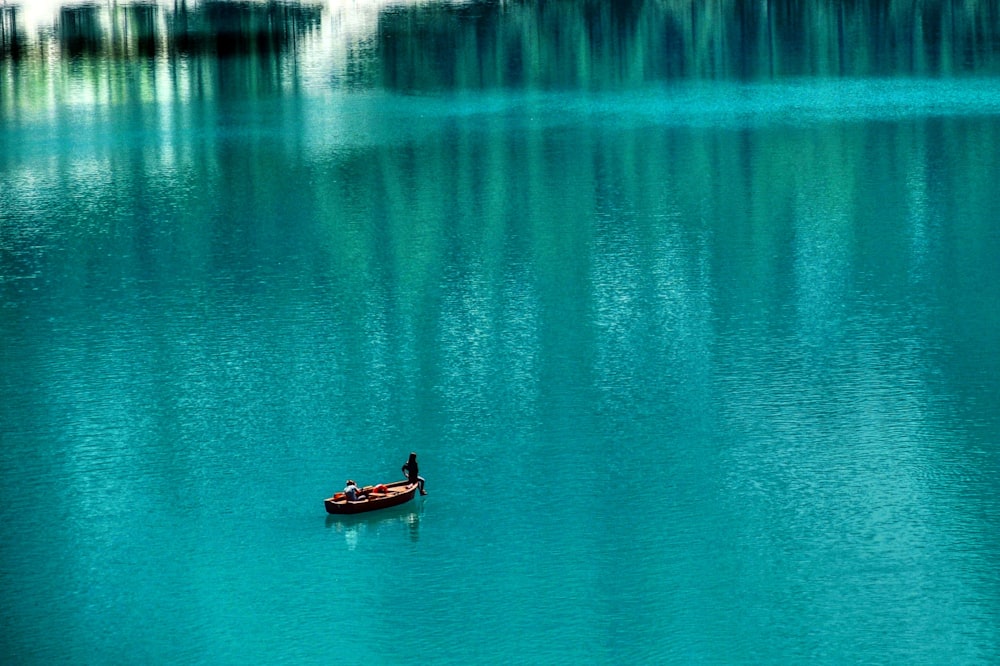 person riding on boat on body of water during daytime