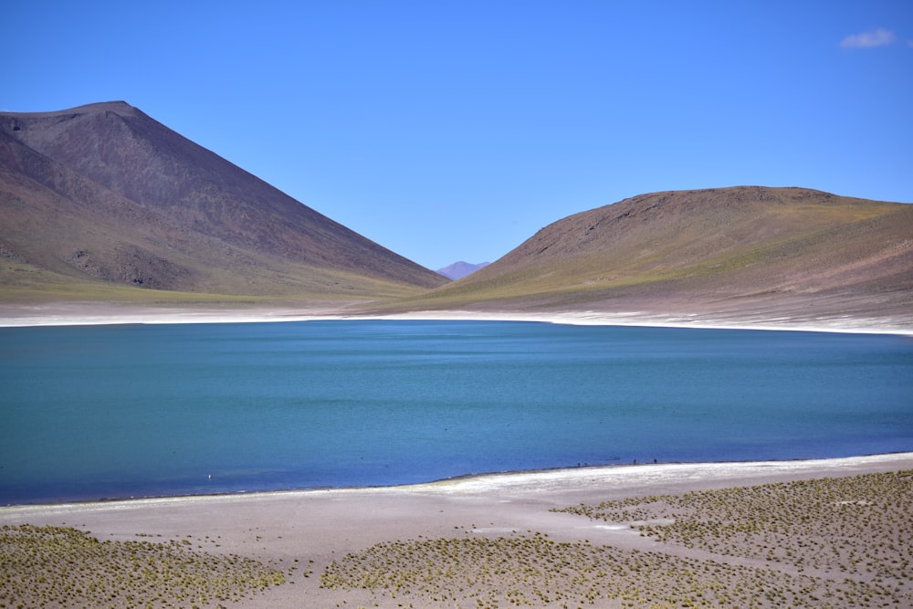 lago perto da montanha sob o céu azul durante o dia