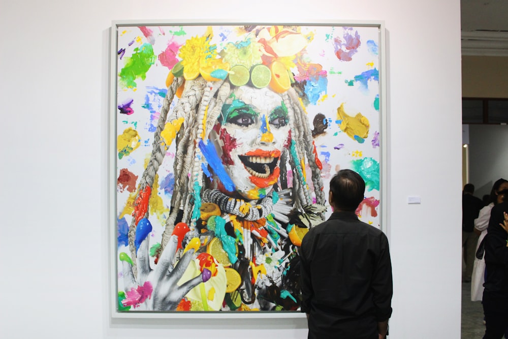 man in black shirt standing beside woman in yellow and white floral dress painting