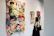 Close-up of colorful, textured artwork displayed on a gallery wall with soft lighting.