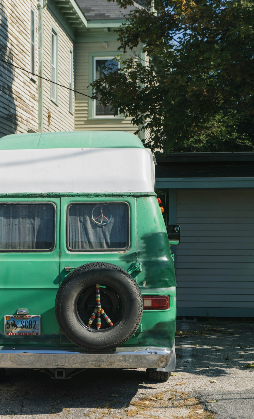 green and white van parked beside white house