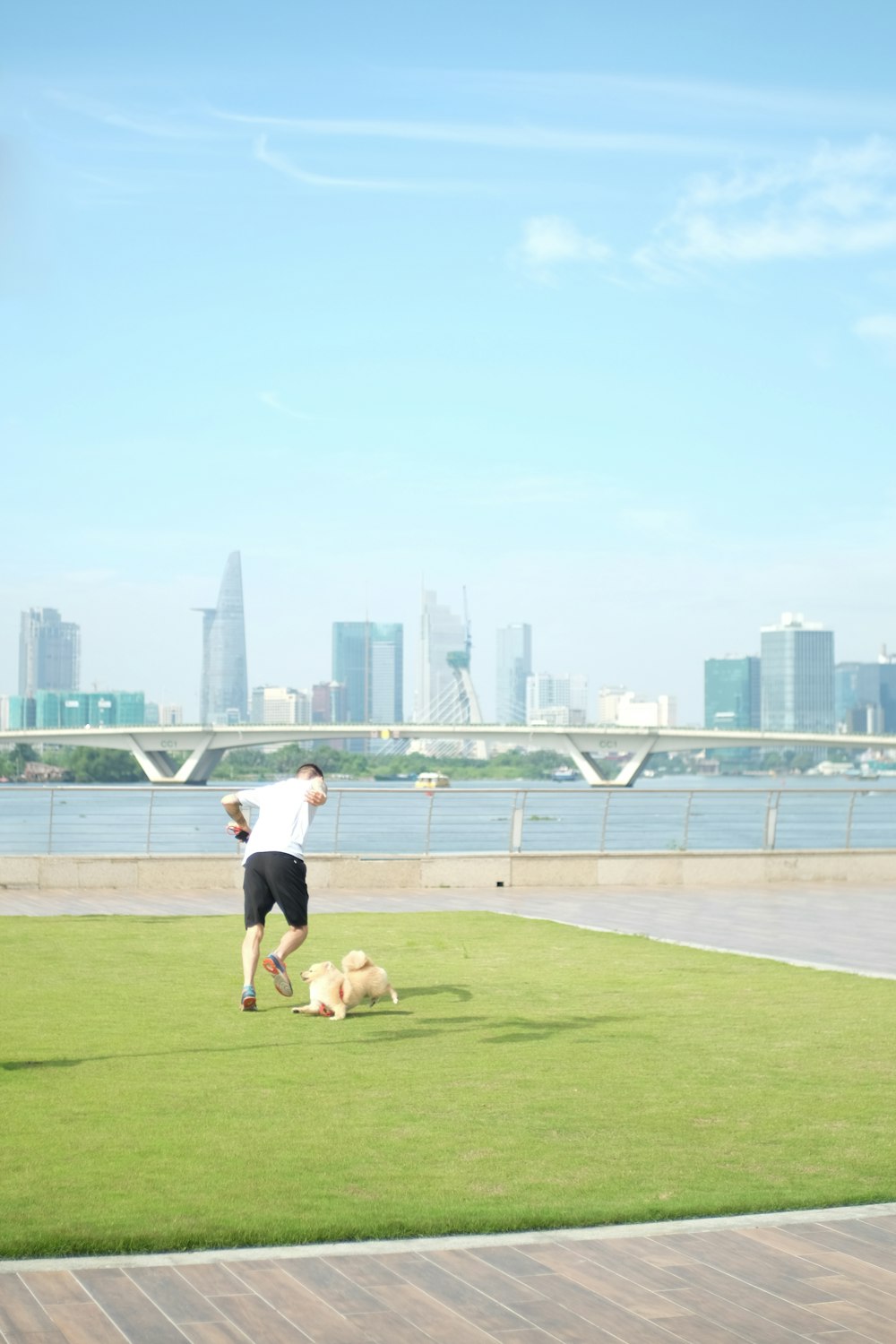 woman in white shirt and black shorts running on green grass field during daytime