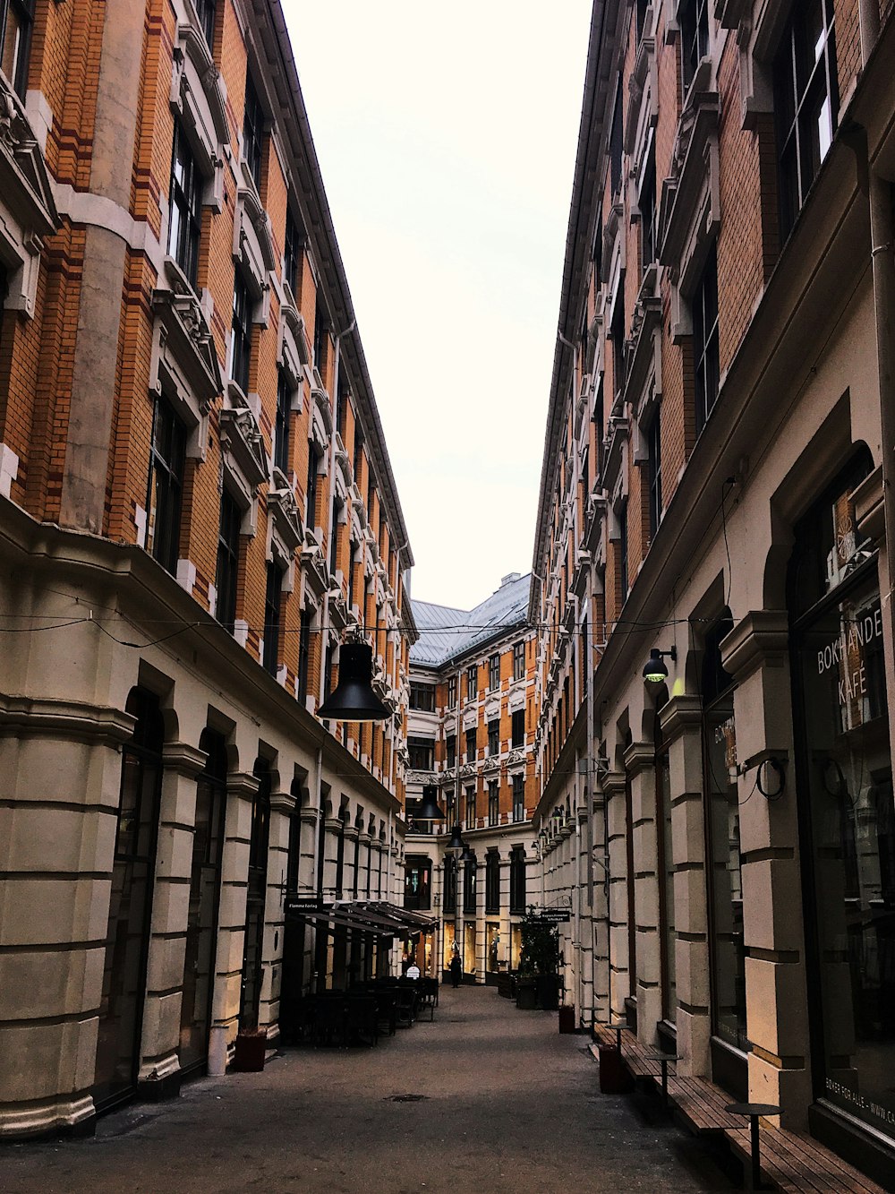 people walking on street between brown concrete buildings during daytime