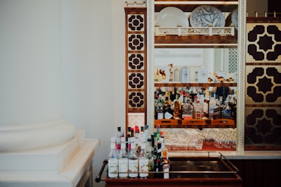 An elegant bar setup featuring black and gold accents with rows of colorful spirits.