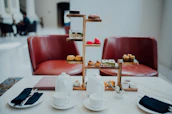 Afternoon tea setup with elegant cups and a view of the city skyline beyond the rooftop.