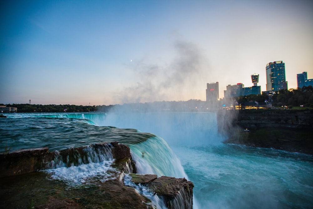 water falls under blue sky during daytime