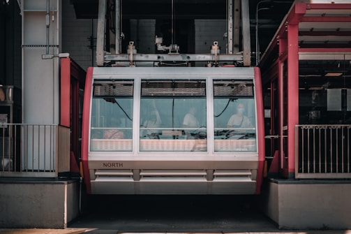 Technical blueprint sketches of cable car components spread out on a wooden desk.