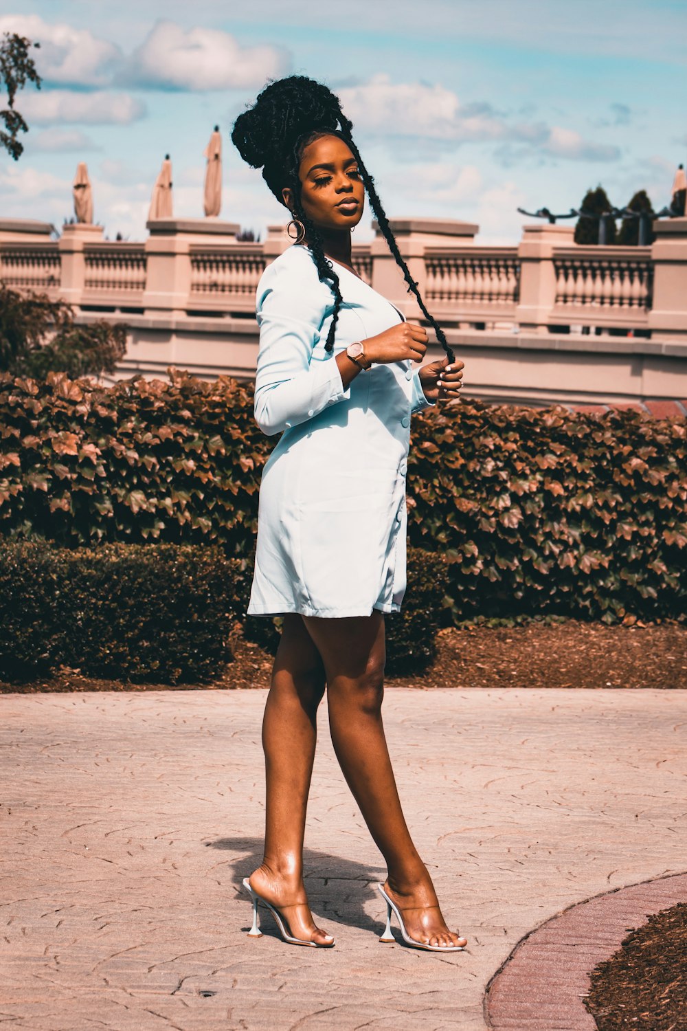 woman in white long sleeve shirt and black skirt standing on brown soil during daytime