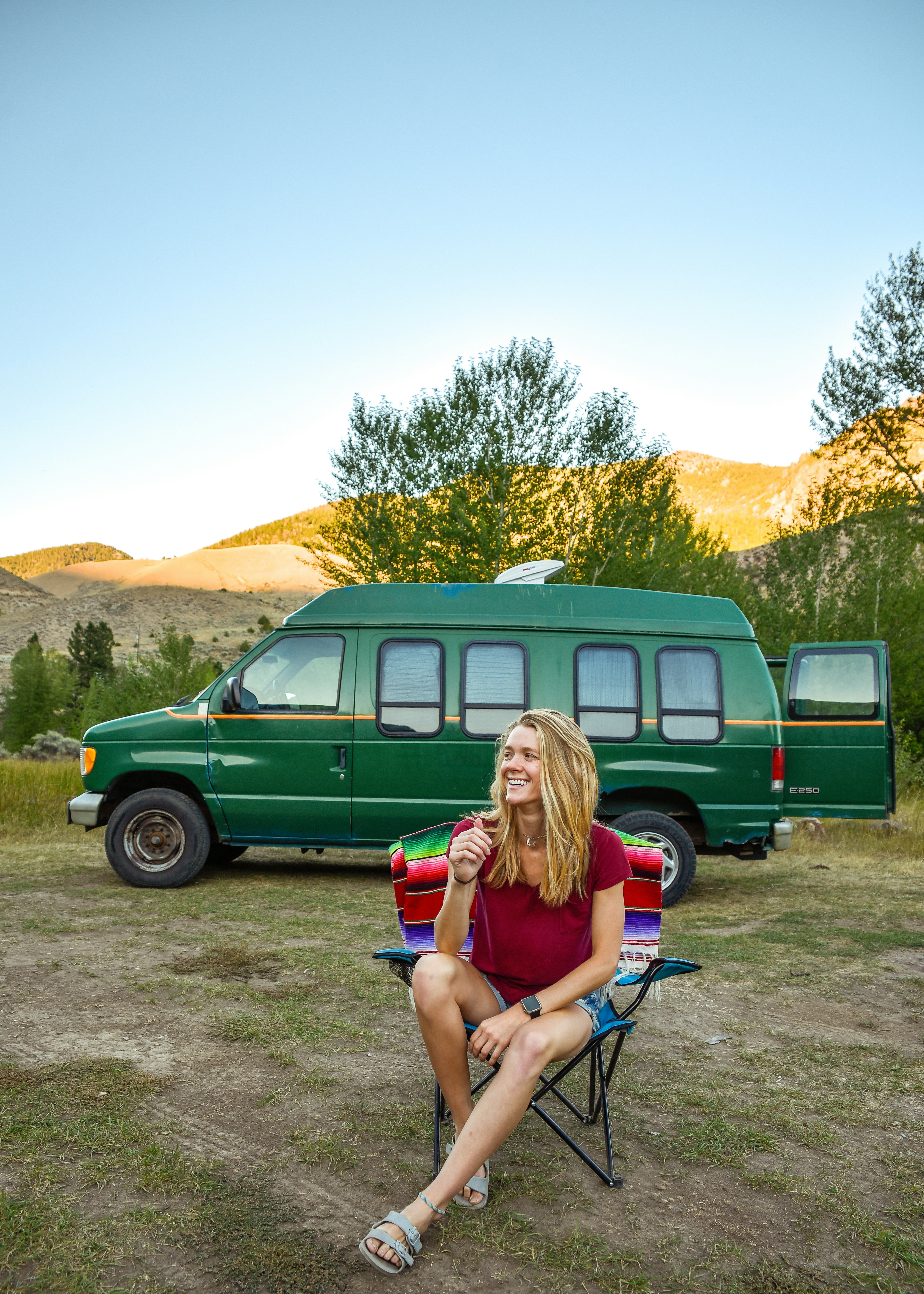 woman in green mini dress sitting on black metal chair near green van during daytime
