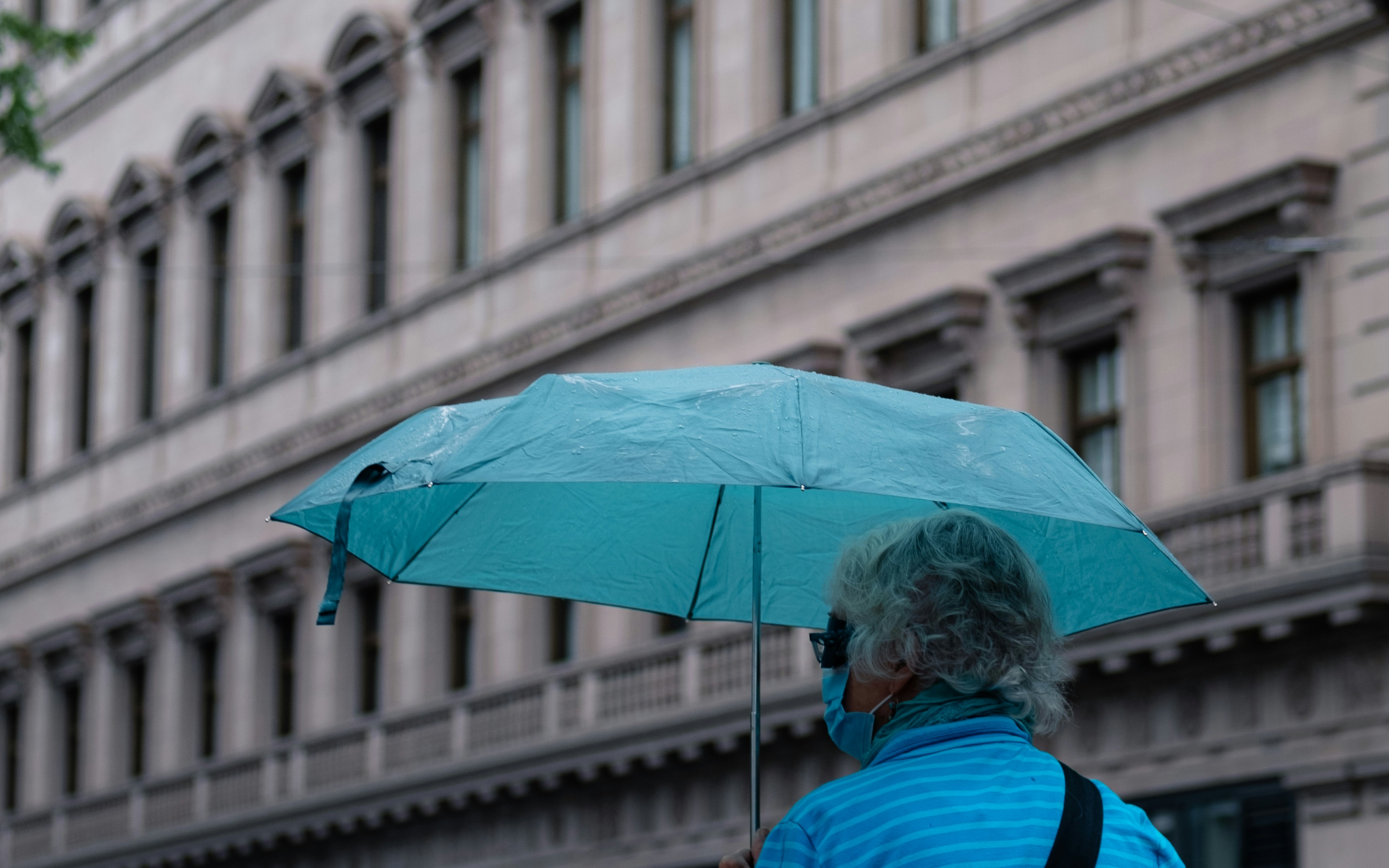Frau in blau-rot gestreiftem Hemd mit Regenschirm