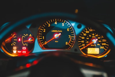 Close-up of a car dashboard with warning lights illuminated.