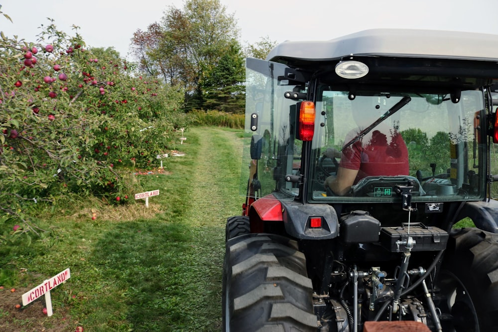 green and black tractor on green grass field during daytime