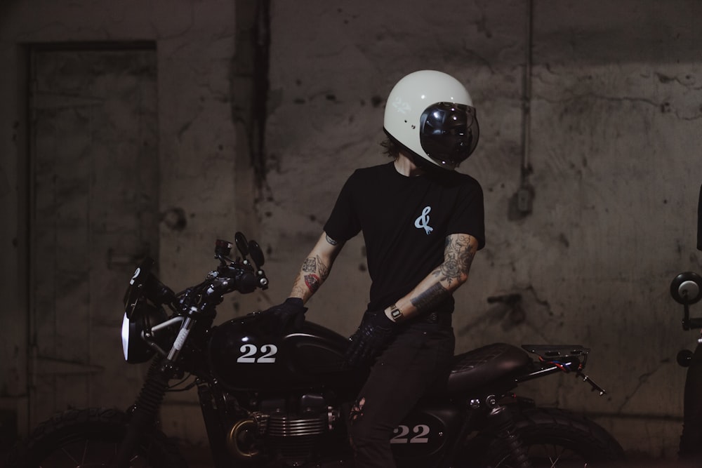T-shirt dell'uomo in girocollo nero che guida sulla moto nera