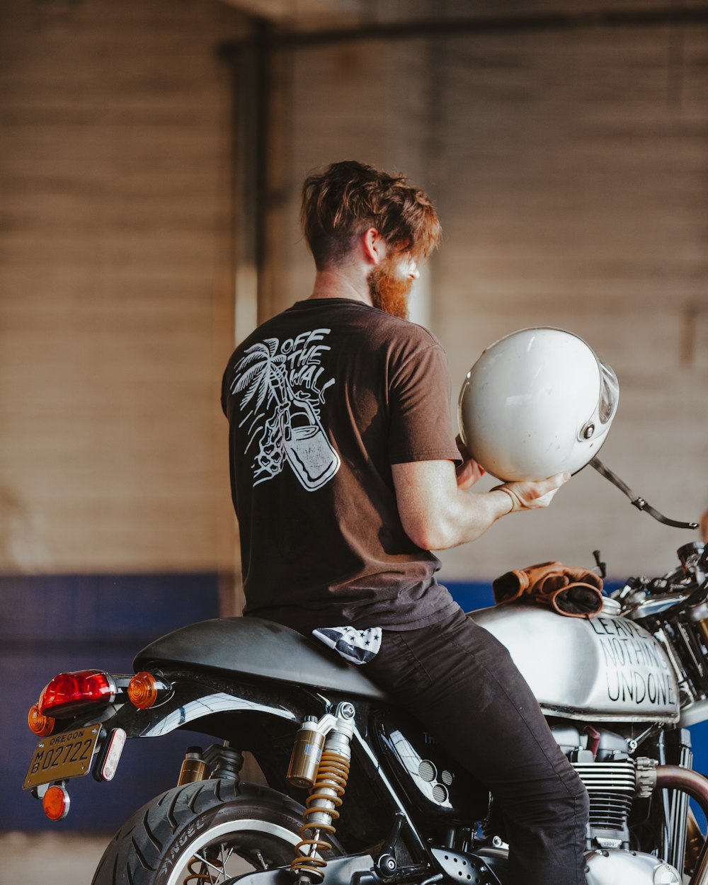 man in black and white crew neck t-shirt riding on motorcycle