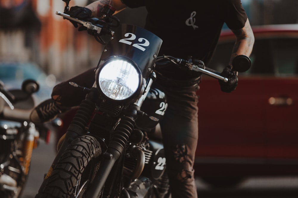 man in black leather jacket riding on black motorcycle