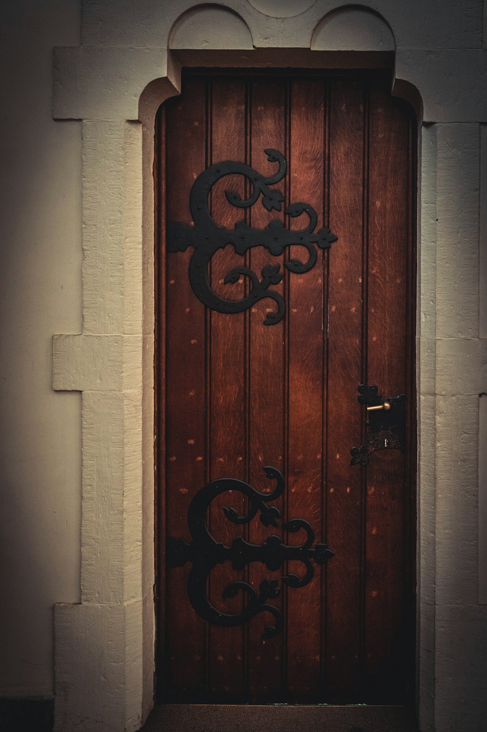 red wooden door with black steel door lever