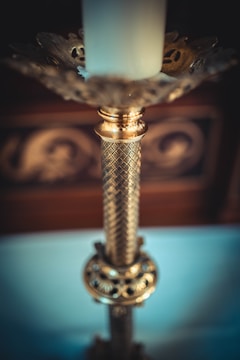 A close-up of a hand-carved candlestick muller resting on a rustic wooden table with soft natural light highlighting its worn texture