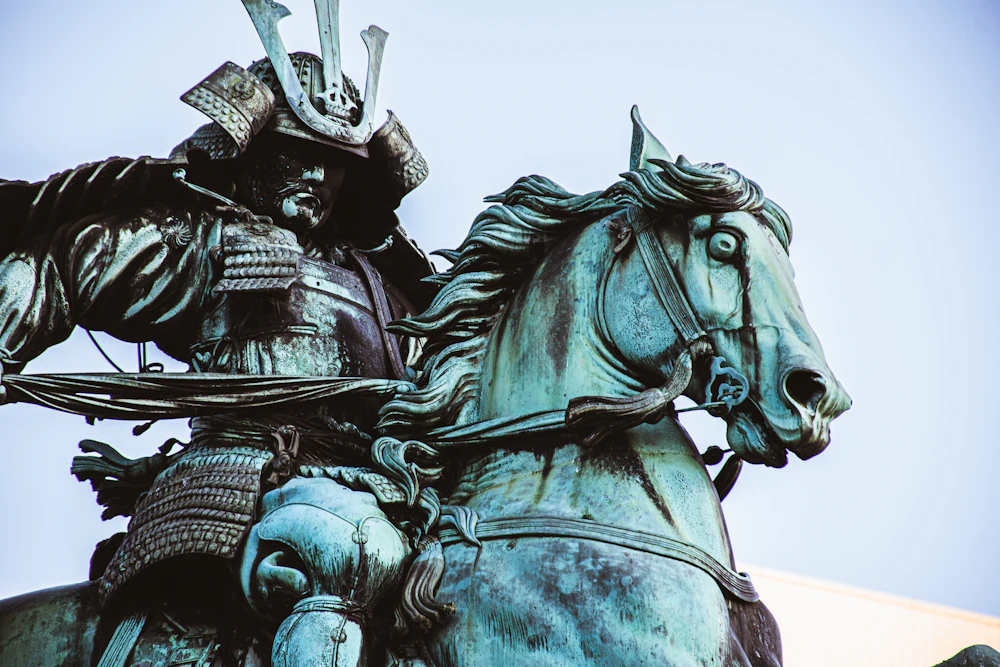 Samurai on horseback statue against the sky