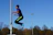 Close-up of an athlete performing plyometric jumps on a training field.