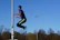 Close-up of an athlete performing plyometric jumps on a training field.
