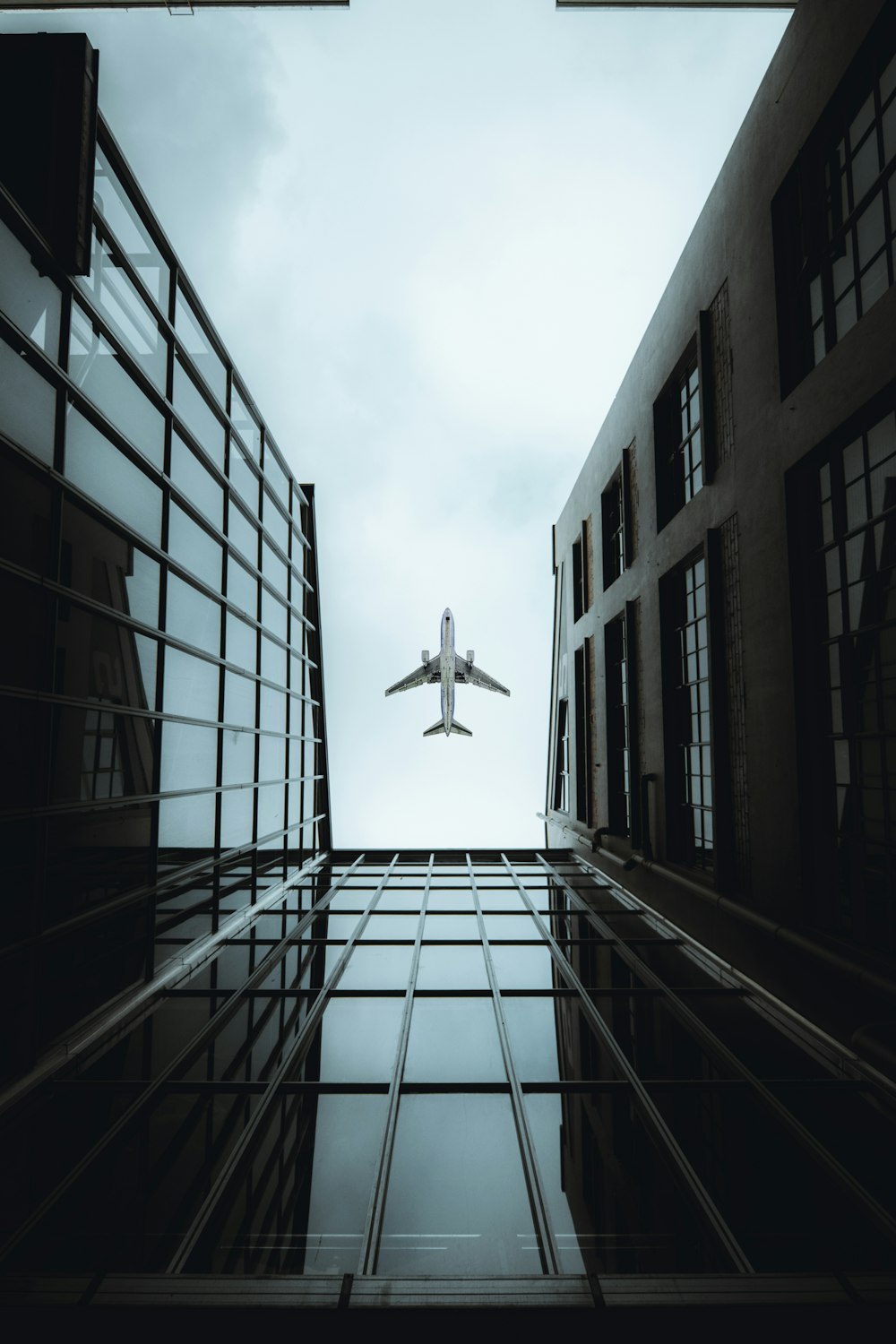 airplane flying over the building during daytime