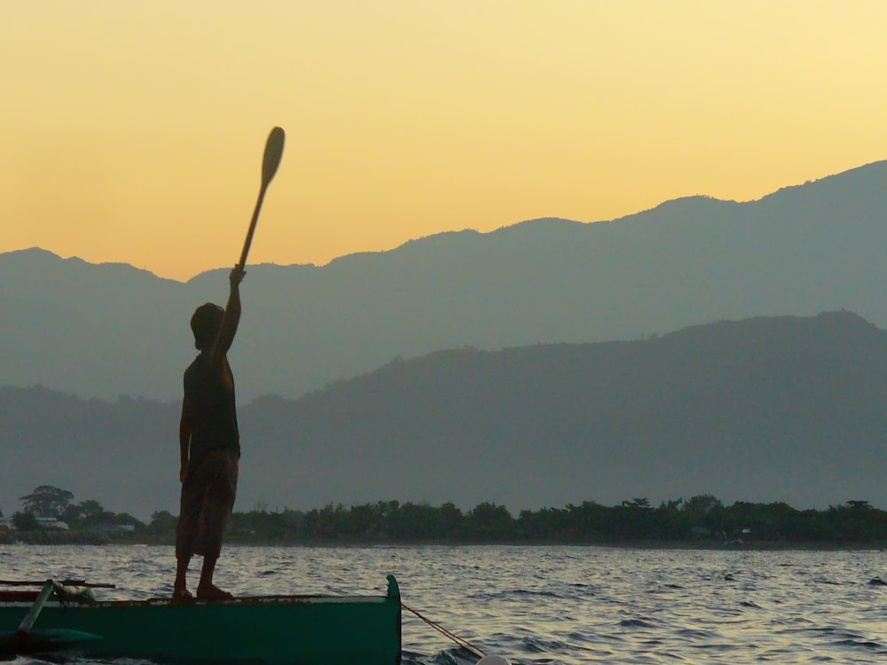 man in black shorts standing on boat during daytime