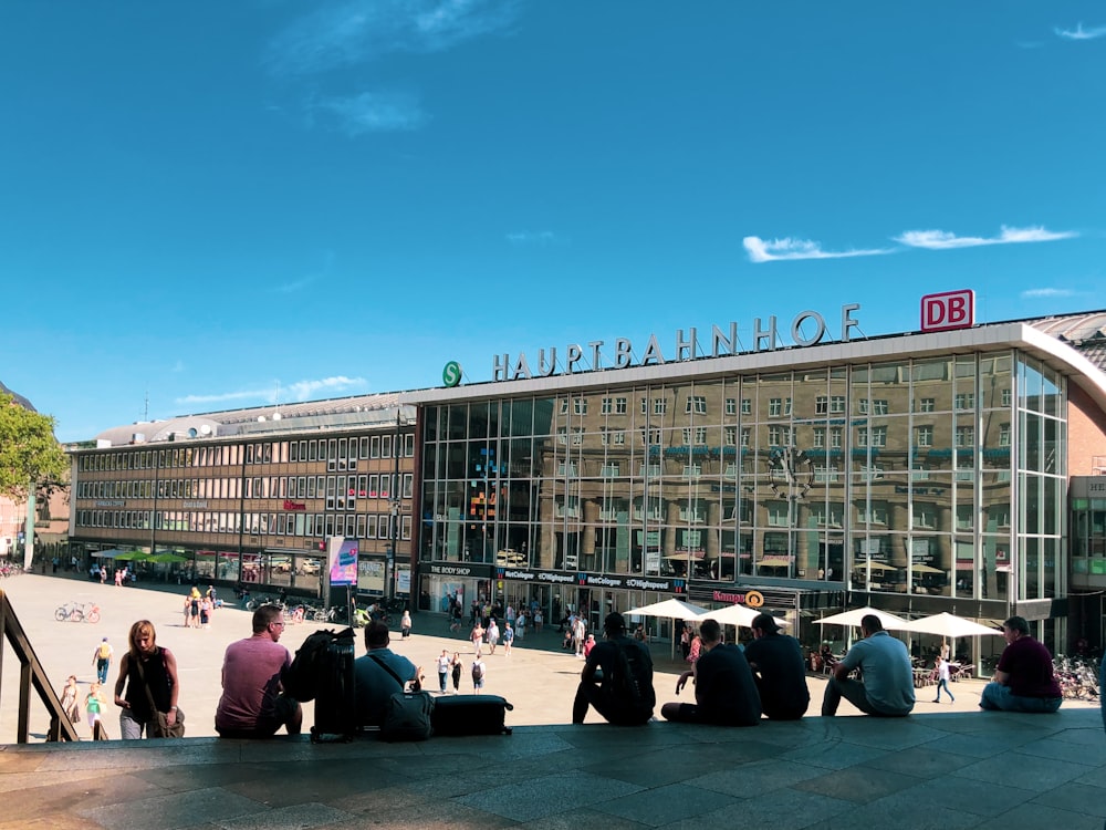 people sitting on bench near building during daytime