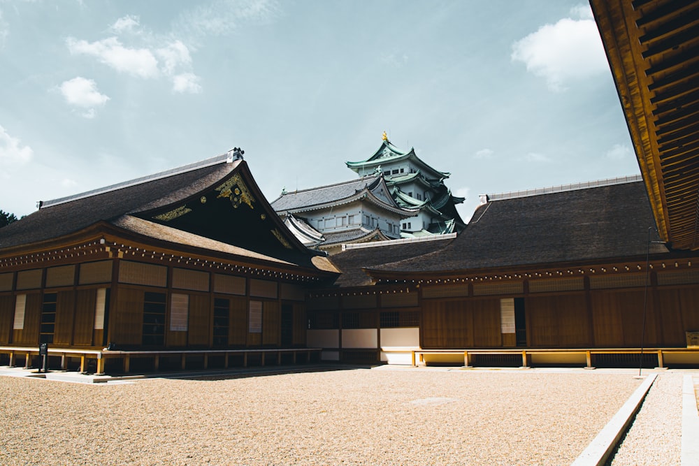 昼間の白い雲の下の茶色と黒のコンクリートの建物