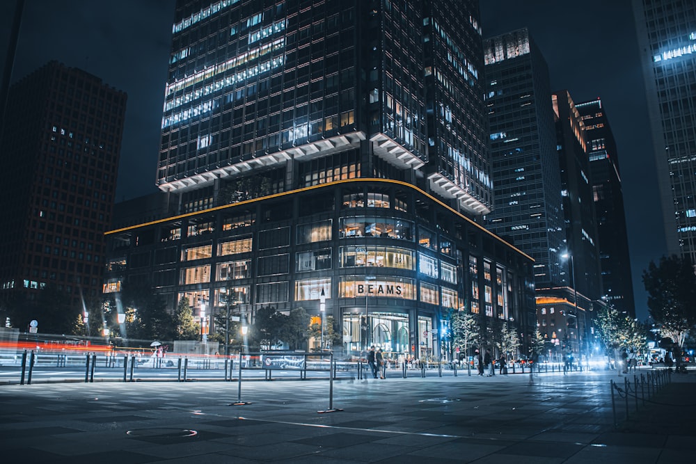 people walking on sidewalk near high rise building during night time