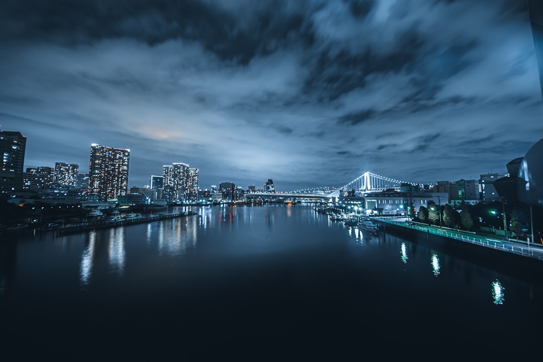 city skyline across body of water during night time