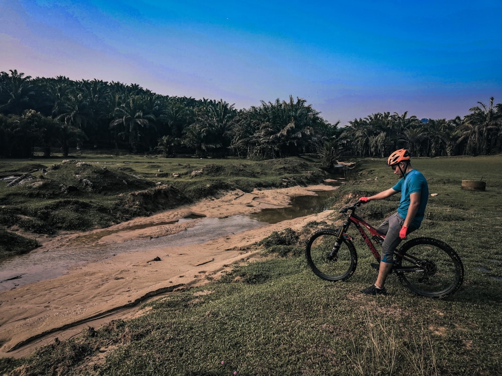 man in blue shirt riding black mountain bike during daytime