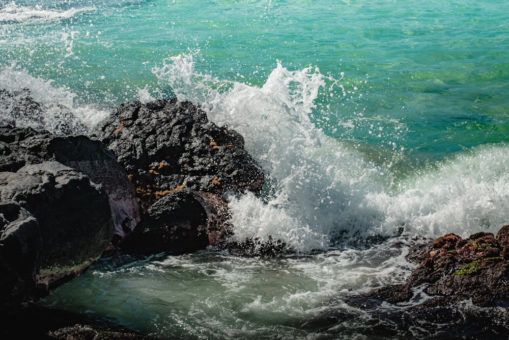 ocean waves crashing on black rock