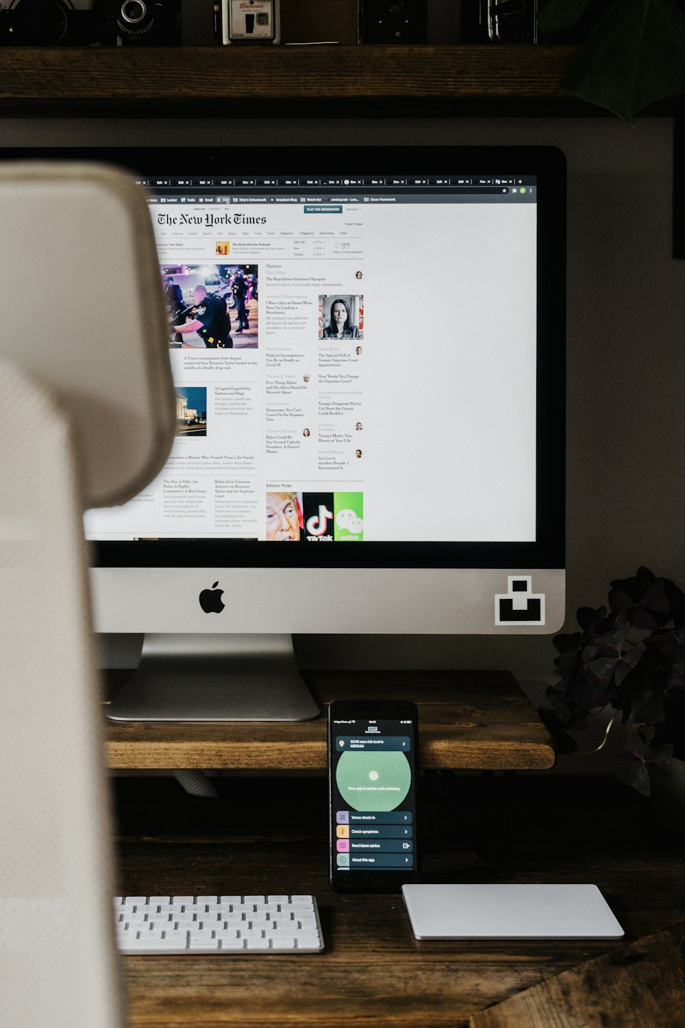 Imac plateado sobre mesa de madera marrón